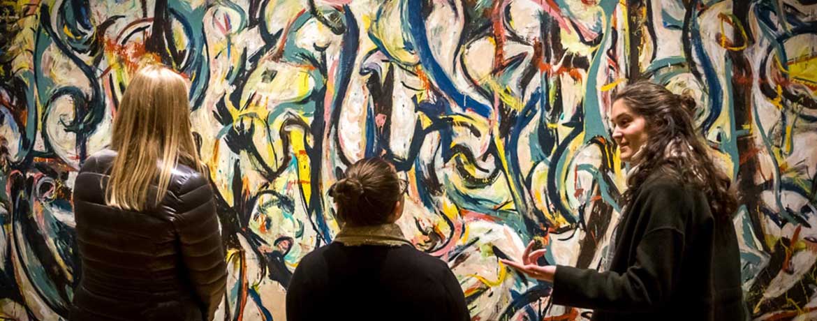 三名学生在哥伦比亚艺术博物馆检查杰克逊·波拉克的一幅画