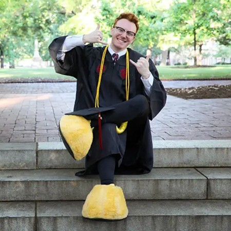 毕业生穿着骄傲的脚坐在马蹄上的台阶上。