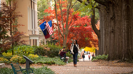 一个秋天，学生走在总统家旁边的砖砌人行道上。