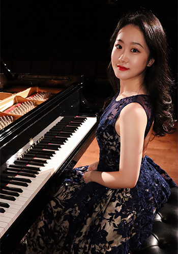 宋梦宇坐在钢琴前的照片