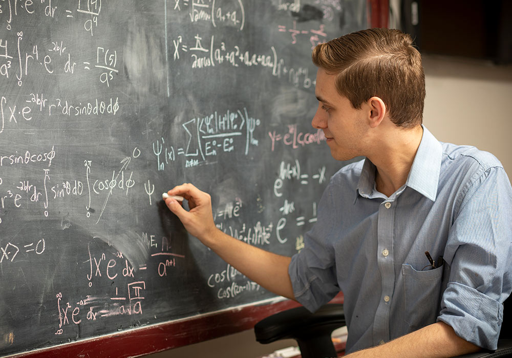 埃里克在黑板上写数学公式。