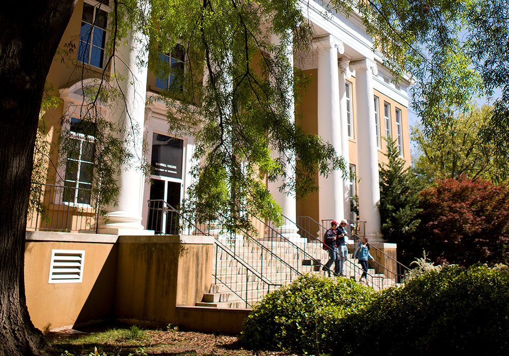 巨大的白色柱子装饰着巴恩韦尔学院的正面，一些学生正走下台阶。