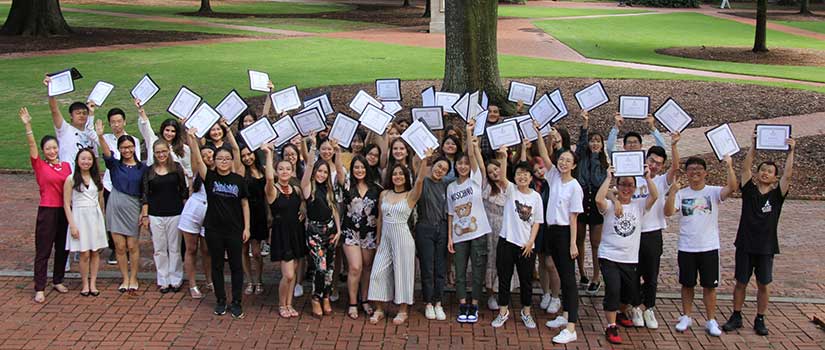 国际学生高举着他们的证书，站在南卡罗来纳大学历史中心被称为“马蹄形”的郁郁葱葱的绿地上bob官方体育登陆