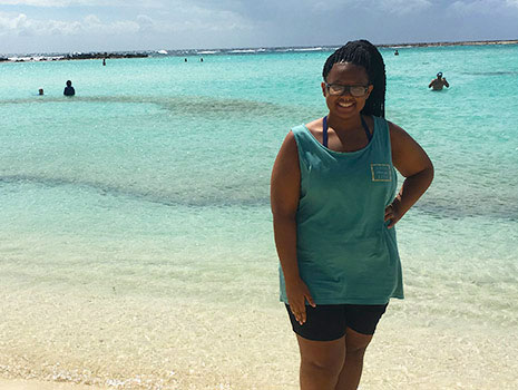 在阿鲁巴留学的扎哈里亚·巴伯站在蓝绿色的海水中