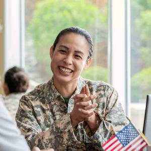在坐在桌微笑的制服的女性退伍军人