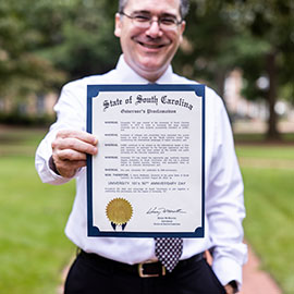 丹·弗里德曼(Dan Friedman)拿着州长在马蹄铁上的公告的实体副本