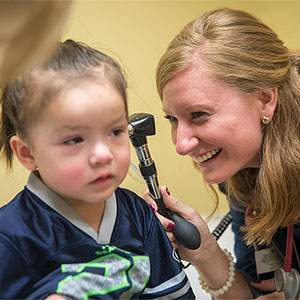 医学院学生调查孩子的耳朵。