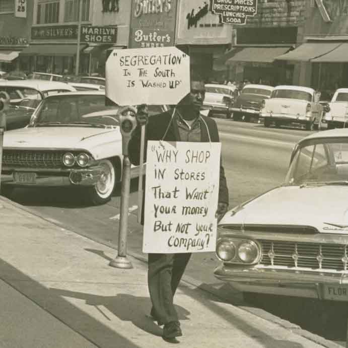 一名黑人男子举着抗议种族隔离的标语