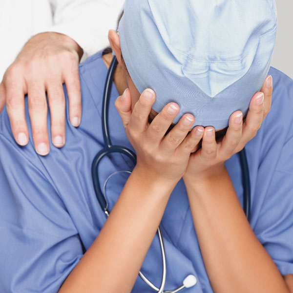卫生保健工作者穿着实习医生风云与他/她的手脸表示失望。