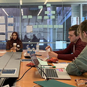 三个国际商学院学生坐在桌子,在笔记本电脑上工作,作为一个类的一部分
